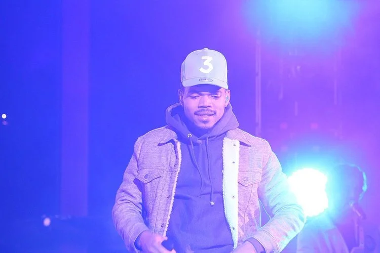 Chance the Rapper performing on stage in a 3 cap